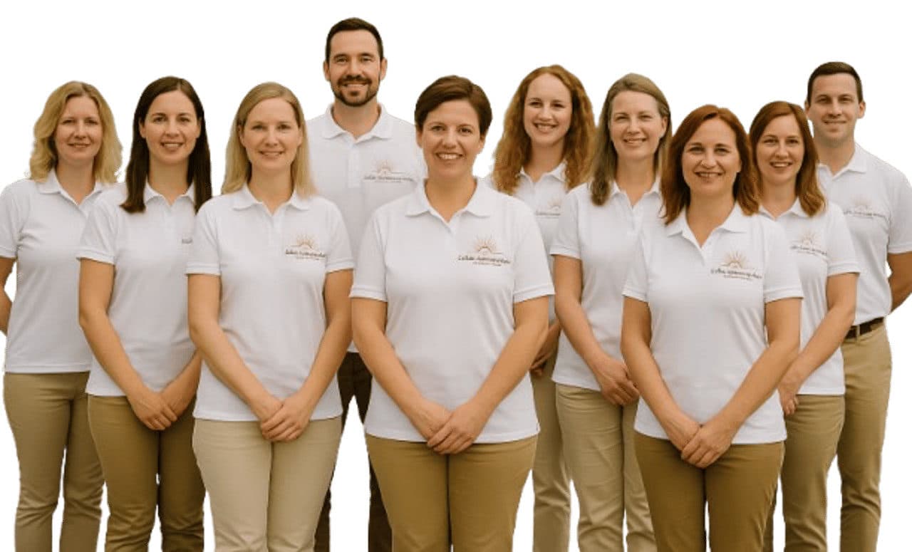 Gruppenfoto eines Praxisteams mit zehn Mitarbeitenden in weißen Poloshirts vor hellem Hintergrund.